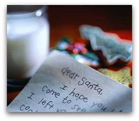 A letter to Santa in the foreground with milk and cookies behind it